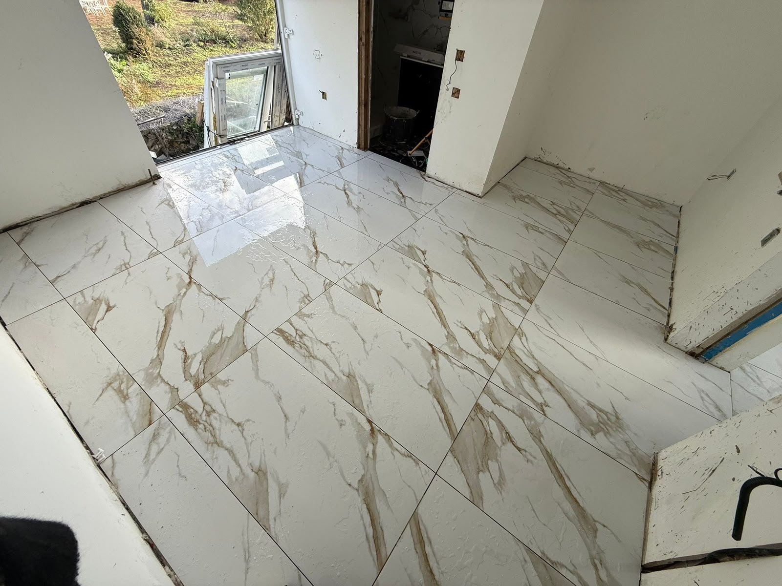 Gold-veined marble-effect floor tiles fitted by SN&J Construction