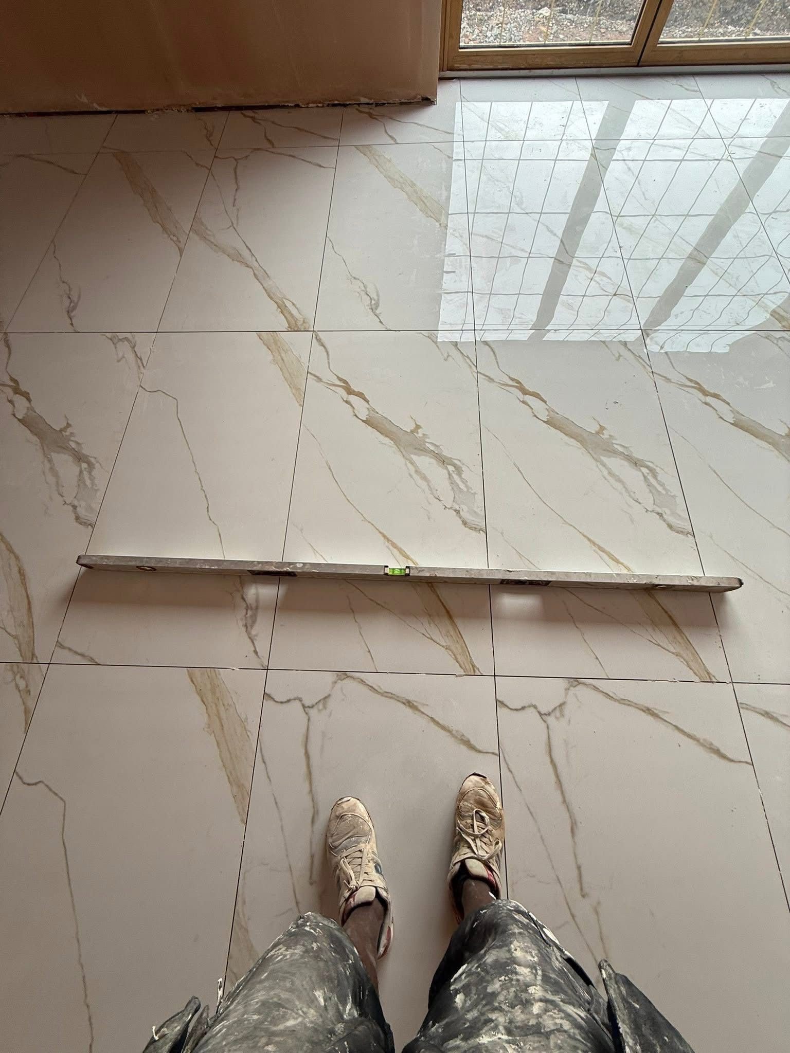 Level tiled floor checked with a spirit level by SN&J Construction