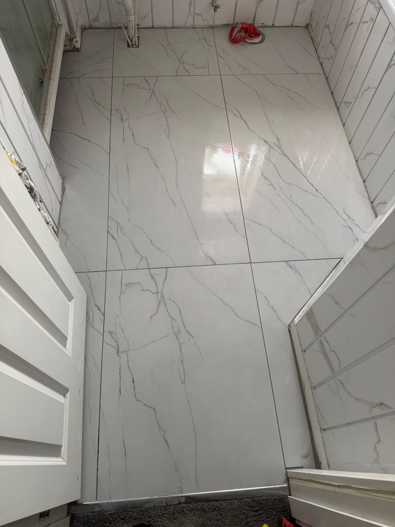 White marble-effect bathroom floor tiles fitted by SN&J Construction